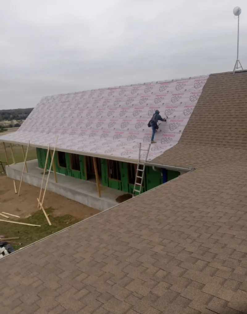 Worker preparing underlayment for a metal roof installation in Norristown